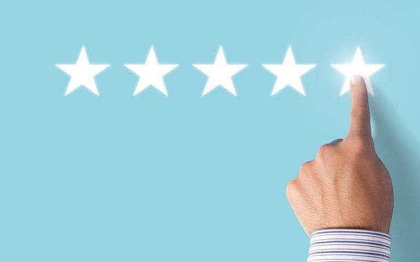 Hand choosing 5 stars rating on blue background - Positive feedback - Fotografie, Obrázek