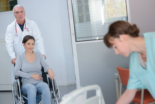 doctor pushing patient in a wheelchair - Fotó, kép