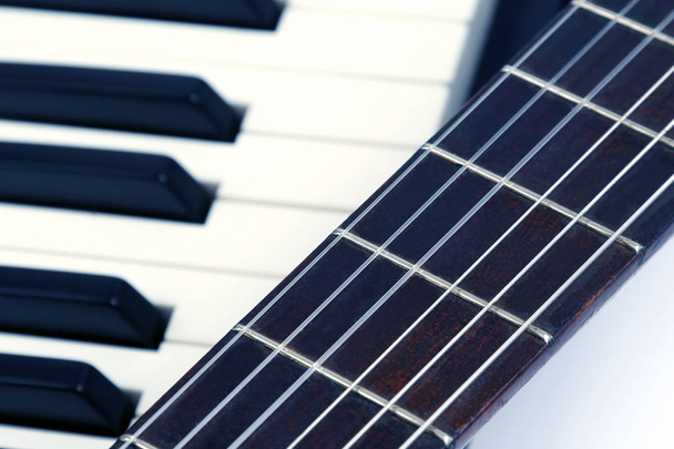 the piano keys and classical guitar close up on white background - Photo, Image