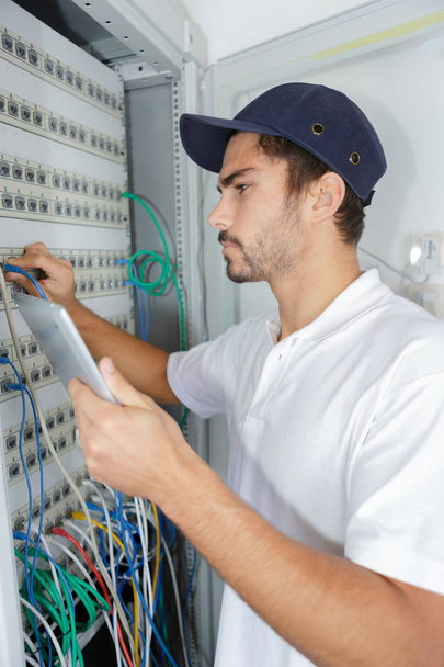 focused electrician applying safety procedure while working on electrical panel - Zdjęcie, obraz