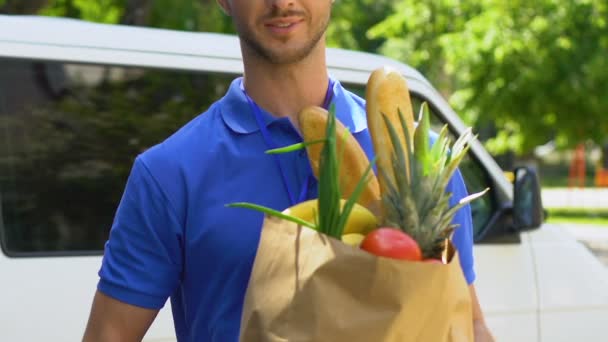 Express service of delivery products from supermarket, courier holding out bag - Séquence, vidéo