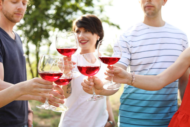 Young people with glasses of wine outdoors. Summer picnic - Photo, Image