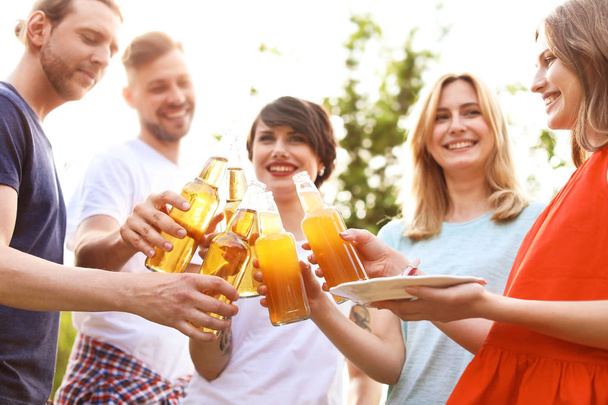 Young people with bottles of beer and food outdoors. Summer barbecue - Φωτογραφία, εικόνα
