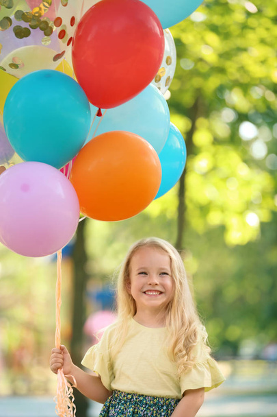 Cute girl with colorful balloons in park on sunny day - Fotografie, Obrázek