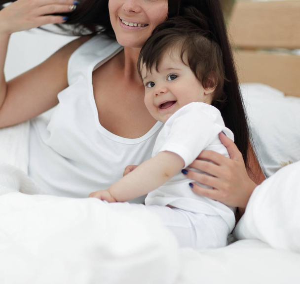 Portrait of a beautiful mother with her baby in the bedroom - Foto, Imagem