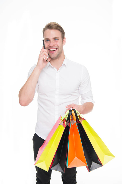 Guy buy clothes online. Online shopping concept. Take advantages online shopping and delivery. Man call to order more items. Man happy holds bunch of bags speak on phone with consultant - Foto, Bild