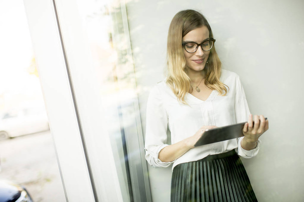 Digitális tábla állva a modern irodai dolgozó fiatal vonzó női vezető - Fotó, kép