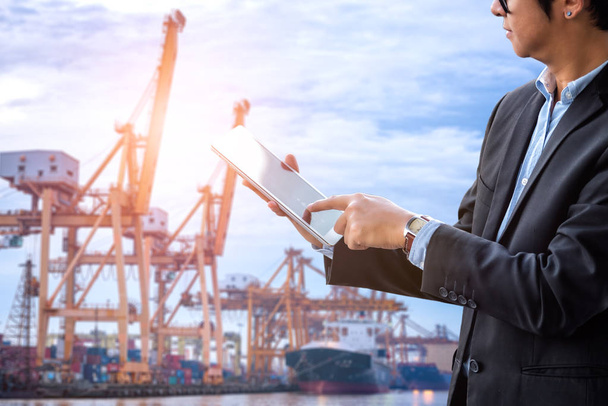 Businessman touch tablet on hand and transportation port import export background - Photo, Image