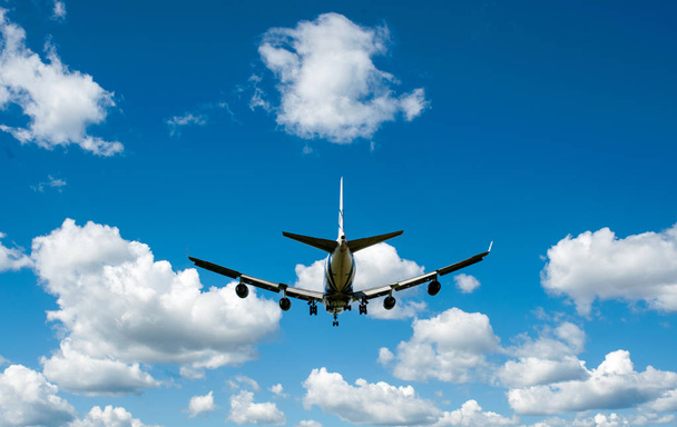 The plane on a background of blue sky and white clouds. - Фото, изображение