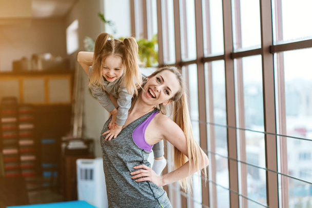 Mom and daughter together perform different exercises - Φωτογραφία, εικόνα