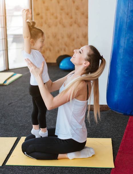 Mom and daughter together perform different exercises - Photo, Image