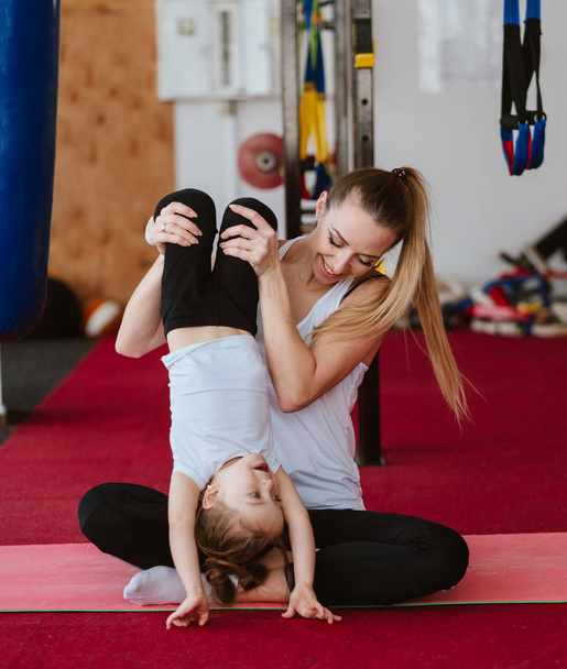Mutter und Tochter machen gemeinsam verschiedene Übungen - Foto, Bild