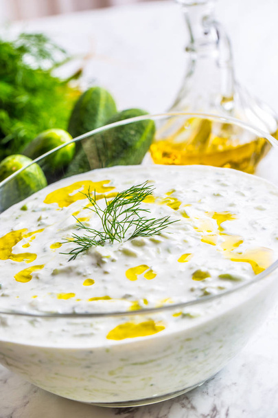 Greek dip sauce or dressing tzatziki prepared  with grated cucumber sour cream yogurt olive oil and fresh dill. - Foto, imagen