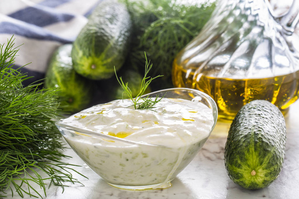 Greek dip sauce or dressing tzatziki prepared  with grated cucumber sour cream yogurt olive oil and fresh dill. - 写真・画像
