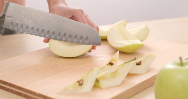Cutting apple into pieces - Фото, изображение