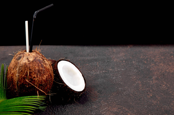 Kokosový koktejl na hnědé pozadí. Letní dovolená pít koncept, tropické koktejly nebo šťávy v kokosu. Kopírovat prostor.  - Fotografie, Obrázek