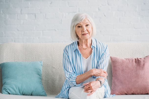 portrait of beautiful grey hair woman resting on sofa at home - Photo, Image