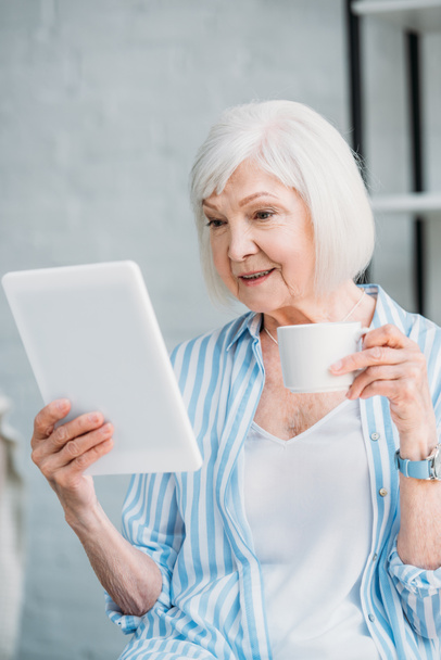 portrait of senior woman with cup of coffee and tablet at home - Foto, Bild