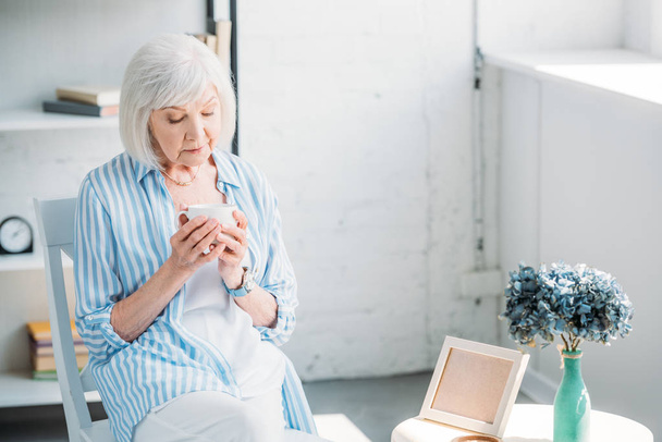 portrait de femme âgée avec tasse de café aromatique dans les mains à la maison
 - Photo, image