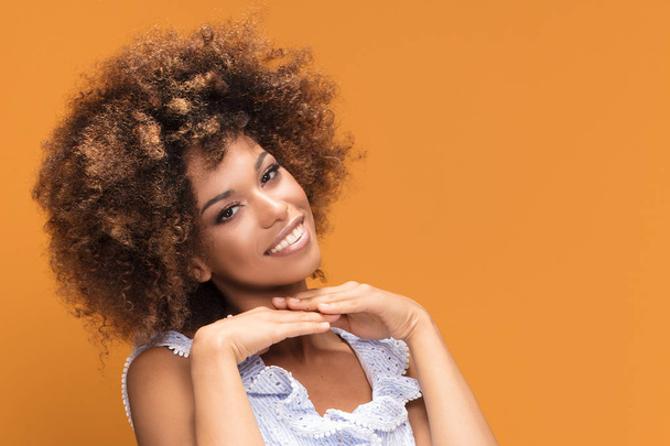 Beauty portrait of smiling african american young woman with afro hairstyle posing on yellow background. - Fotoğraf, Görsel