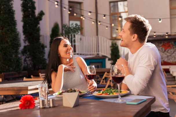 Dark-haired woman laughing with her man sitting on fancy terrace - Photo, Image