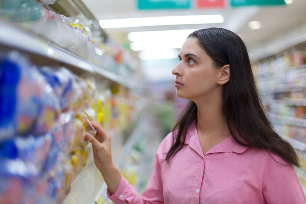 Hermosa mujer comprando comida, verduras y frutas en el supermercado
 - Foto, imagen