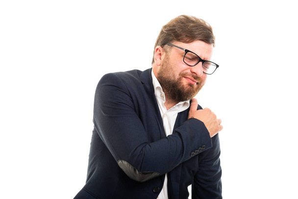 Portrait d'homme d'affaires montrant un geste de douleur à l'épaule isolé sur fond blanc avec espace publicitaire copyspace
 - Photo, image