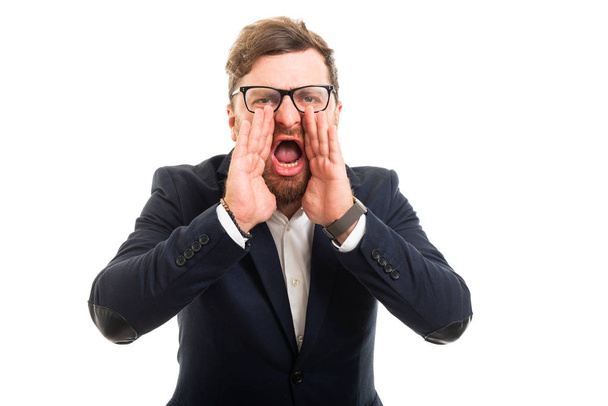 Retrato de homem de negócios cutucando mãos na boca gritando isolado no fundo branco com área de publicidade copyspace
 - Foto, Imagem
