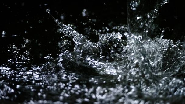 水の健康ドリンクや輝く水の液体のきれいな、純粋な自然の新鮮さを表す黒の背景色にスプラッシュ  - 写真・画像