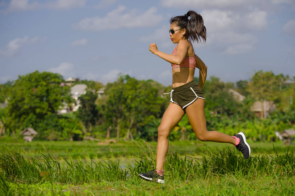 attrayant et très en forme asiatique sport femme entraînement course séance d'entraînement à champ vert paysage arrière-plan travailler dur dans un mode de vie sain et compétitif coureuse concept de jogging
 - Photo, image