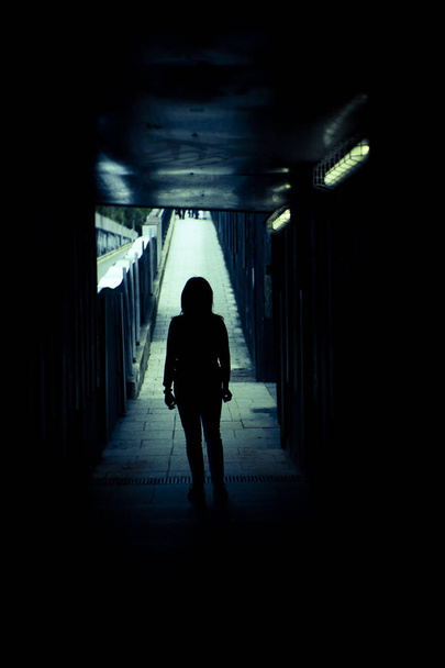 Vrouw alleen en verdrietig in een tunnel. Scène van mysterie en verwoesting - Foto, afbeelding