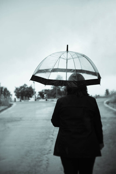 Yağmurda şeffaf şemsiye ile tanınmaz halde kadın - Fotoğraf, Görsel