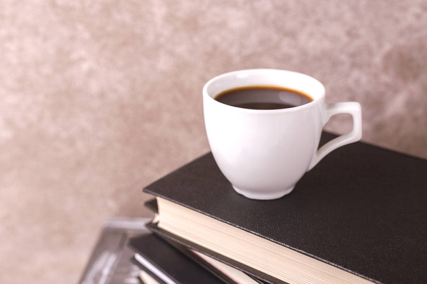 Tasse heißen Kaffee, Plaid und Bücher auf dem Tisch. Bildungskonzept. Selektiver Fokus - Foto, Bild