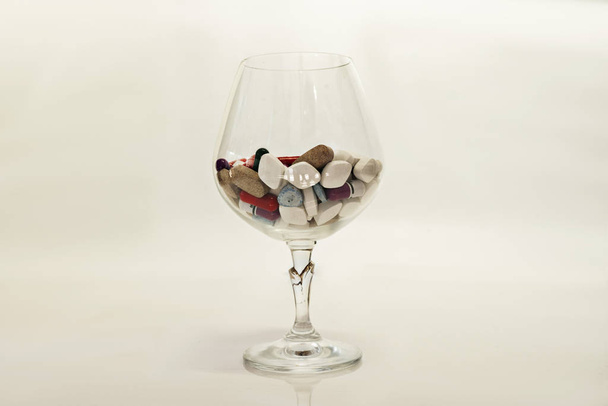 pillole in bicchiere di vino su sfondo bianco
 - Foto, immagini
