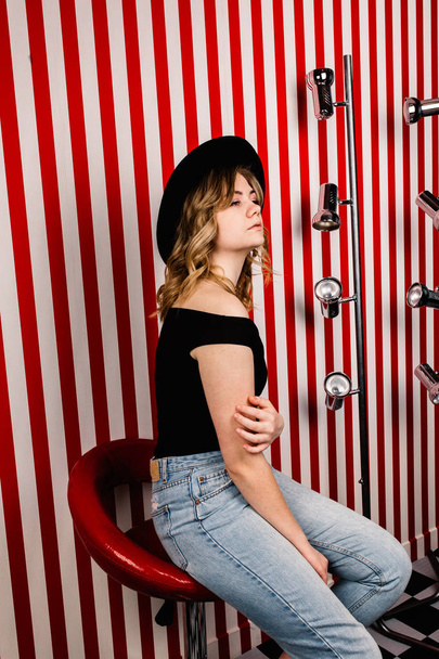 young  beautiful woman in hat sitting in studio - Foto, imagen