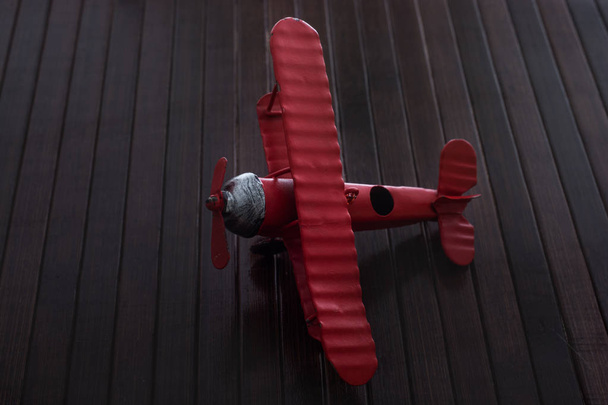 avion jouet de couleur rouge est sur une texture en bois
 - Photo, image