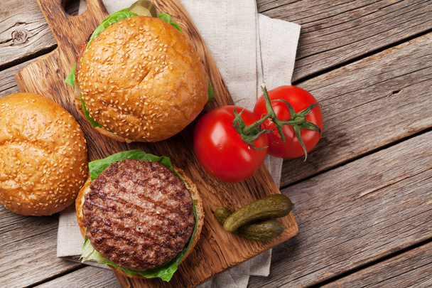 Sığır eti, domates, peynir, salatalık ve marul ile yemek lezzetli ızgara ev yapımı hamburger. Üstten Görünüm - Fotoğraf, Görsel
