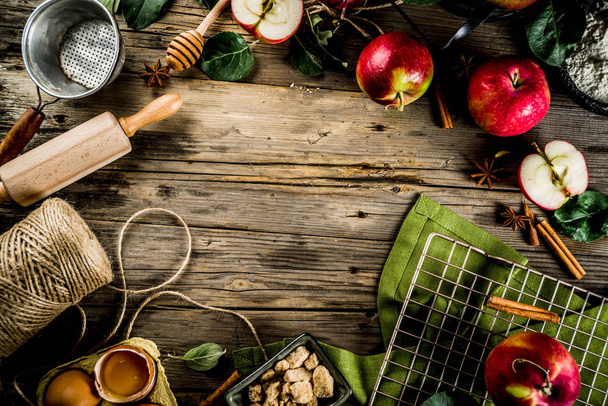 Herbst Kochen Hintergrund, Apfelkuchenbackkonzept, frische rote Äpfel, süße Gewürze, Zucker, Mehl, Nudelholz, Eier, Backutensilien, Holz Hintergrund Kopierraum - Foto, Bild