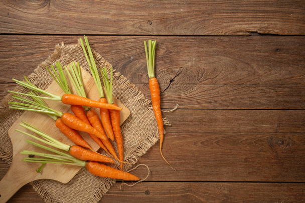 Pile of fresh baby carrots on wooden background - Zdjęcie, obraz