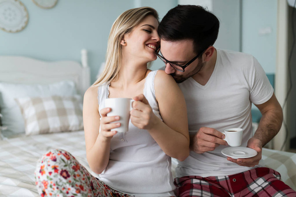 Romantic young couple having fun in bedroom together - Фото, изображение