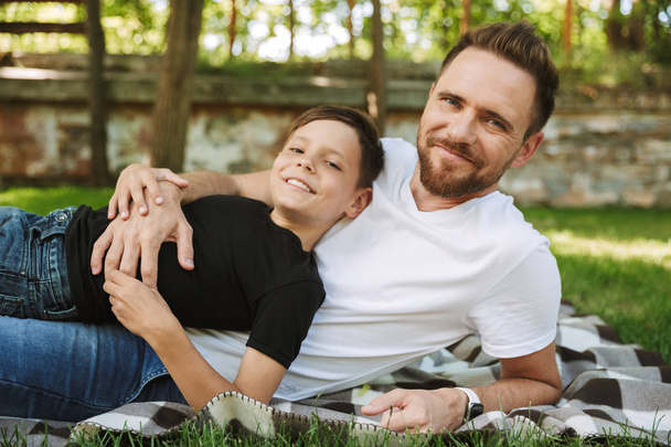 Genç Baba gülümseyen bir görüntü var eğlenceli küçük oğlu ile açık havada park doğada. - Fotoğraf, Görsel