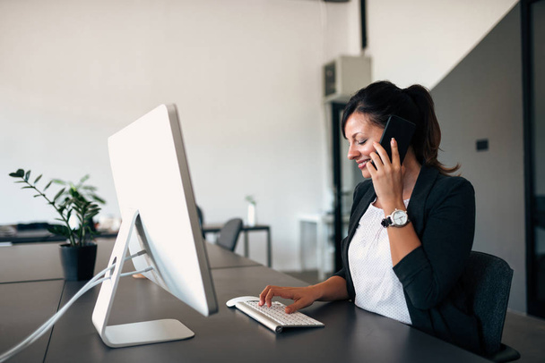 Businesswoman in modern office with laptop. - Zdjęcie, obraz
