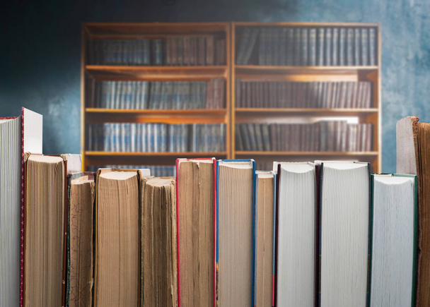 Двенадцать разных книг на фоне библиотеки
 - Фото, изображение