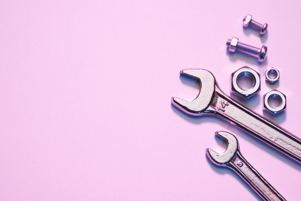vista superior de llaves, tuercas y tornillos en la superficie rosa
 - Foto, Imagen