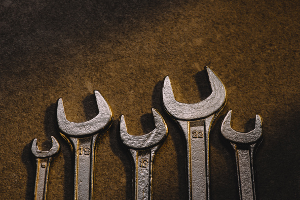 top view of different wrenches on brown surface - 写真・画像