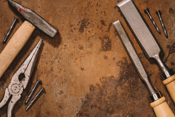 tendido plano con viejas herramientas mecánicas en la superficie marrón
 - Foto, Imagen