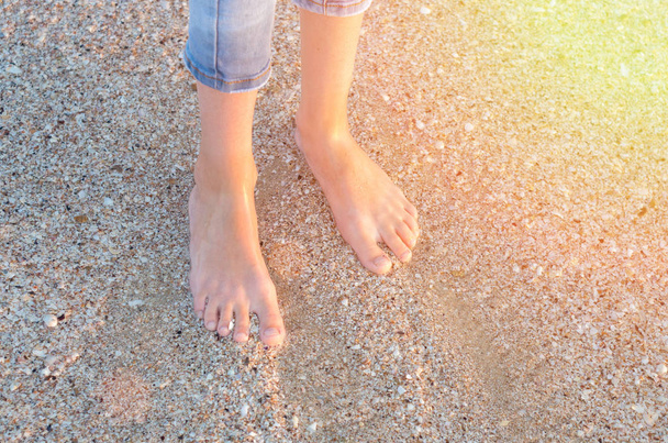 pernas de crianças na água do mar na praia, vista superior
 - Foto, Imagem