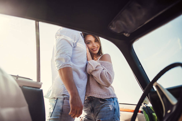 Romantic couple is standing near green retro car on the beach. Handsome bearded man and attractive young woman with vintage classic car. Love story. - Foto, immagini