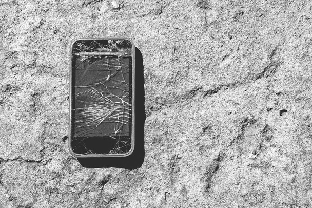 Uno smartphone rotto. Smartphone con schermo rotto su sfondo di cemento
 - Foto, immagini