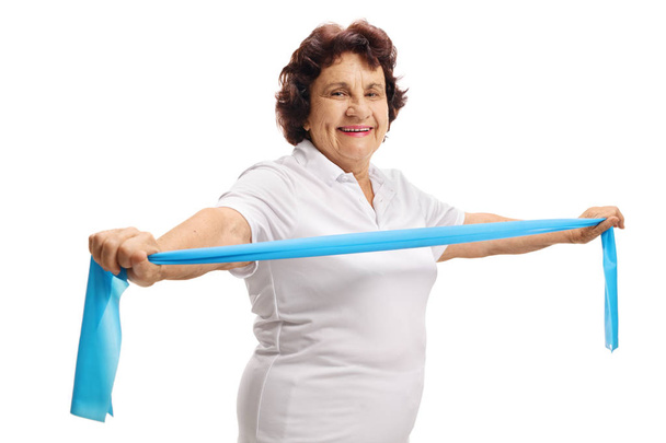 Senior lady exercising with a rubber band isolated on white background - Fotografie, Obrázek